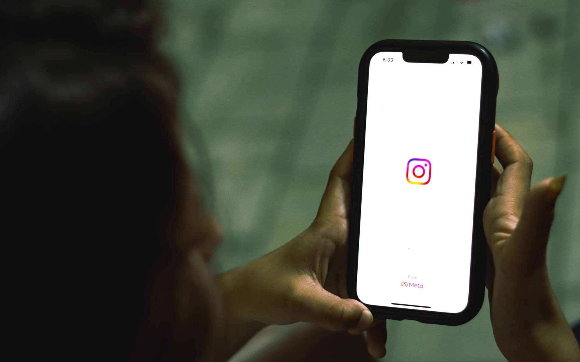 Hand hält ein modernes Smartphone mit geöffneter Social-Media-App