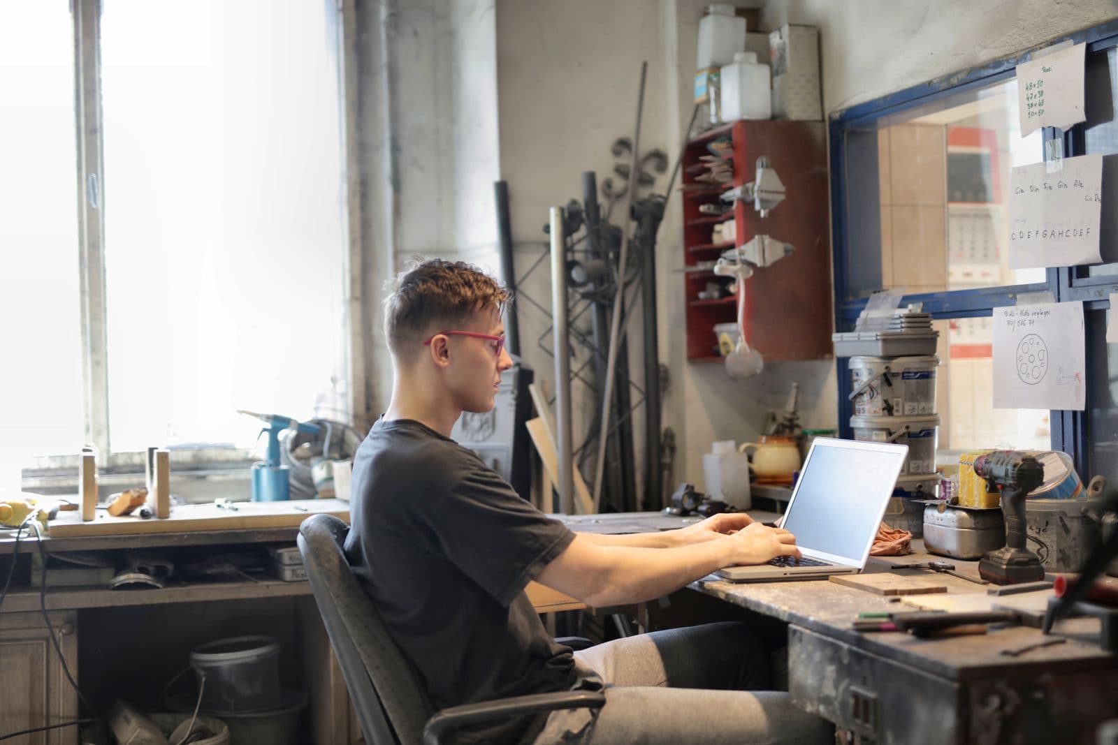 Self-employed person working on a laptop in their workshop